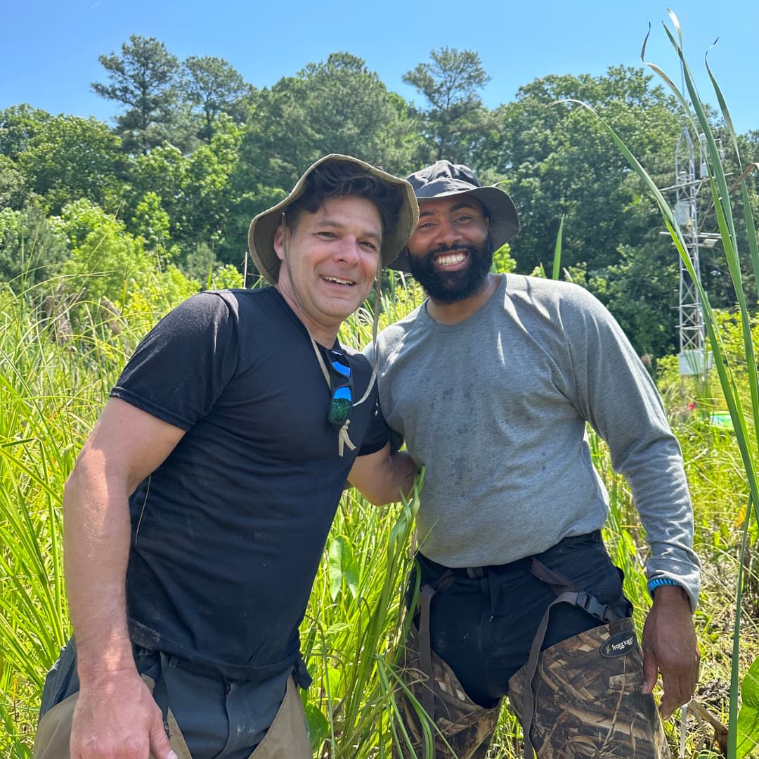 Picture of faculty member Chris gough with student in the field posing for a picture.
