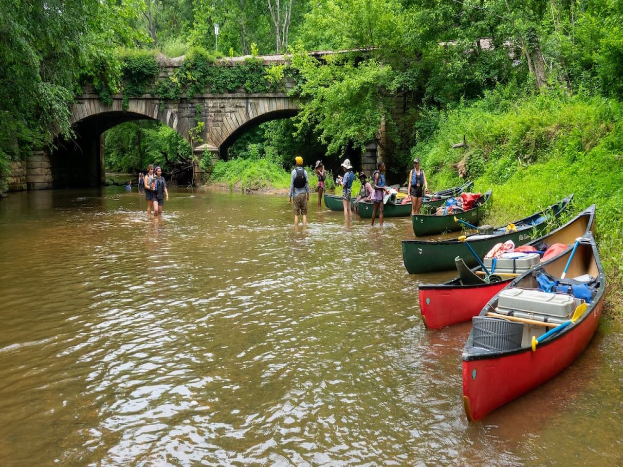 Professor Carr and students standing in a river studying sediments.