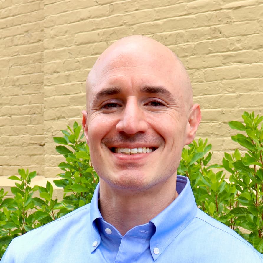 Professor Gaston Jofre-Rodriguez smiling with a brick background