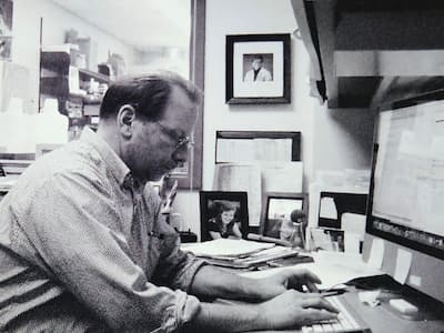 Blac and White photo of Dr. Rob Tombes working at his desk