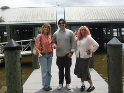 Three students standing on dock in front of the Rice Rivers Center